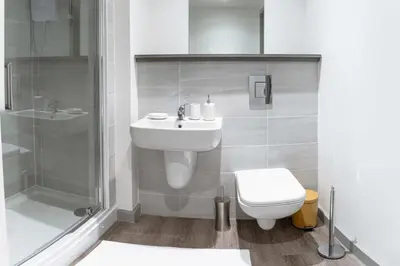 a bathroom with a toilet and a shower and a sink at Contemporary 1 Bed Apartment in Central Liverpool in Liverpool