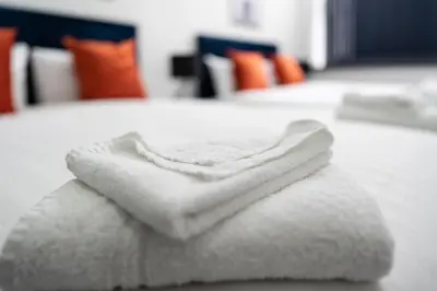 a pile of white towels sitting on a table at New Zealand House Apartments by Happy Days in Liverpool