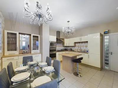 a kitchen with a glass dining table and chairs at The Beach House, Luxury Apartments in Blackpool