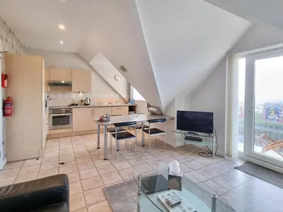 a large living room with a table and a kitchen at The Beach House, Luxury Apartments in Blackpool