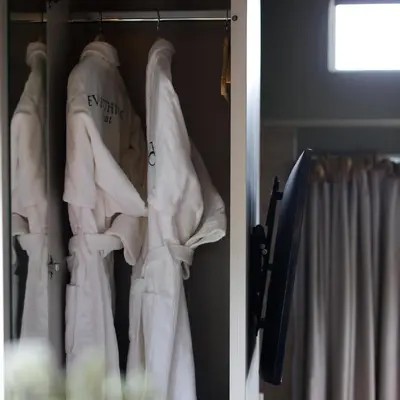 a closet filled with white shirts and a curtain at Everything Retreat in Mellor