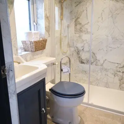 a bathroom with a toilet and a sink and a shower at Everything Retreat in Mellor