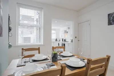 a dining room with a table and chairs and a kitchen at DENEBANK LODGE - Strictly NO Parties in Liverpool