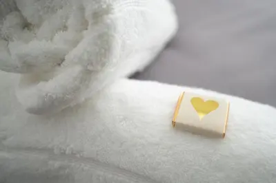 a small card with a yellow heart on a bed at DENEBANK LODGE - Strictly NO Parties in Liverpool
