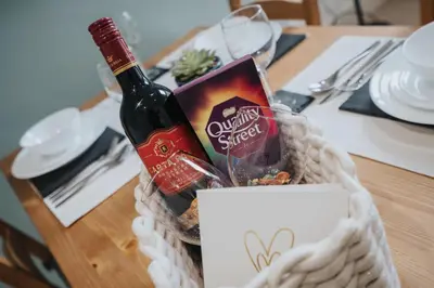 a bottle of wine sitting in a basket on a table at DENEBANK LODGE - Strictly NO Parties in Liverpool