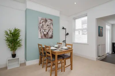 a dining room with a table and a lion painting on the wall at DENEBANK LODGE - Strictly NO Parties in Liverpool