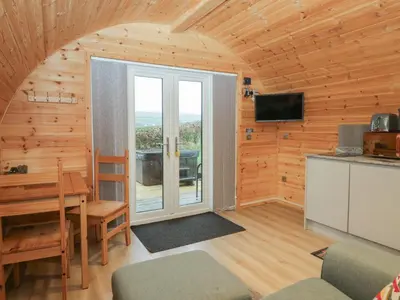a room with a dining table and a sliding glass door at Holly in Ulverston