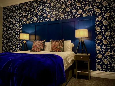 a blue bedroom with a bed with a blue headboard at Captivating 4-Bed Hot Tub House in Blackpool in Blackpool