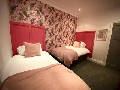 two beds in a room with red headboards at Captivating 4-Bed Hot Tub House in Blackpool in Blackpool