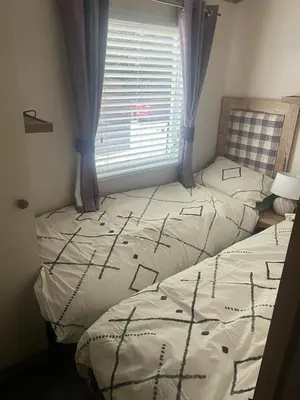 two twin beds in a room with a window at Luxury 6 Berth Caravan, Marton Mere in Blackpool