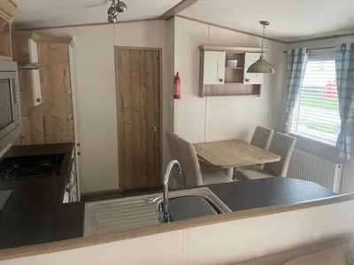 a kitchen and dining room with a table and a sink at Luxury 6 Berth Caravan, Marton Mere in Blackpool