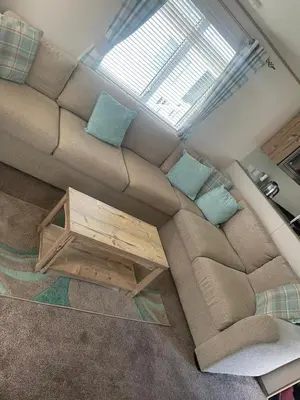 a living room with a brown couch with blue pillows at Luxury 6 Berth Caravan, Marton Mere in Blackpool