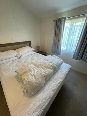 a white bed in a bedroom with a window at LA07 Oceanview in Morecambe