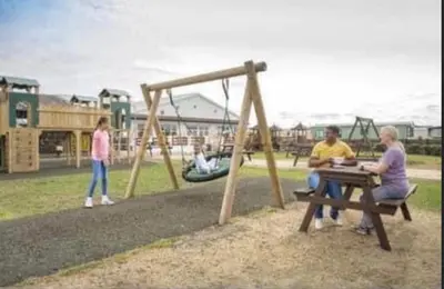 two people sitting at a picnic table in a park at LA07 Oceanview in Morecambe