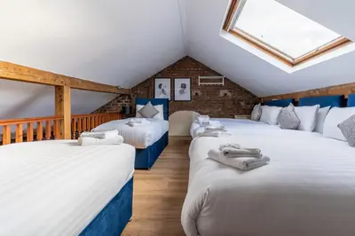 three beds in a attic room with a skylight at Rainford Gardens by UStay Aparthotels in Liverpool