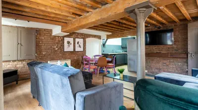 a living room with blue furniture and a brick wall at Rainford Gardens by UStay Aparthotels in Liverpool