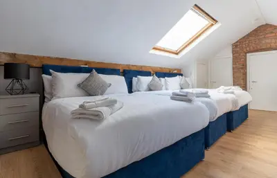 a bedroom with a large bed with towels on it at Rainford Gardens by UStay Aparthotels in Liverpool