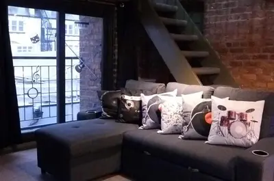 a couch with pillows on it in a living room at Button Street by UStay Aparthotels in Liverpool