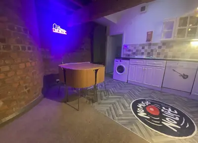 a kitchen with a table and a purple light at Button Street by UStay Aparthotels in Liverpool