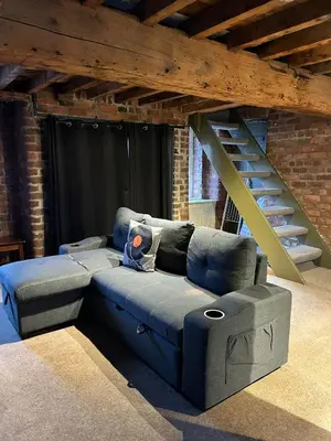 a blue couch in a room with a staircase at Button Street by UStay Aparthotels in Liverpool