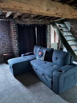 a blue couch in a room with a staircase at Button Street by UStay Aparthotels in Liverpool
