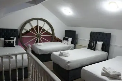 a room with two beds and a large wheel at Button Street by UStay Aparthotels in Liverpool