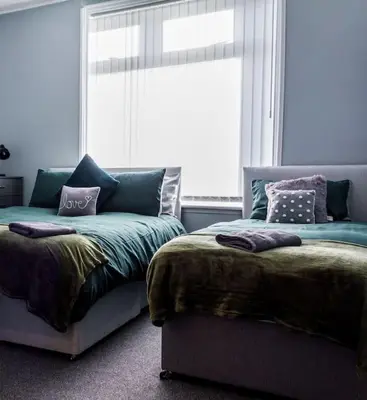 a bedroom with two beds and a window at Modern 5 Bed Near LFC Stadium in Liverpool