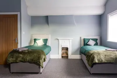 two beds in a room with blue walls at Modern 5 Bed Near LFC Stadium in Liverpool