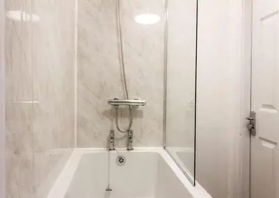 a bathroom with a bath tub with a shower at Modern 5 Bed Near LFC Stadium in Liverpool