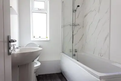 a white bathroom with a sink and a tub and a toilet at Modern 5 Bed Near LFC Stadium in Liverpool