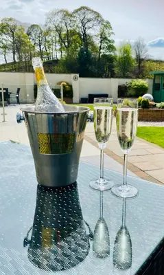 three wine glasses and a bucket on a table at Hodder Cottage in The Ribble Valley in Whalley