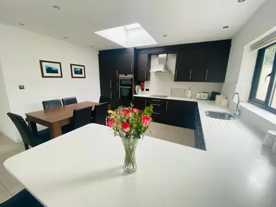 a vase of flowers on a white table in a kitchen at Hodder Cottage in The Ribble Valley in Whalley