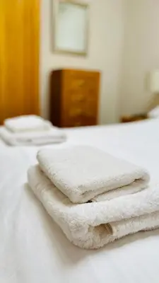a pile of towels sitting on top of a bed at Hodder Cottage in The Ribble Valley in Whalley