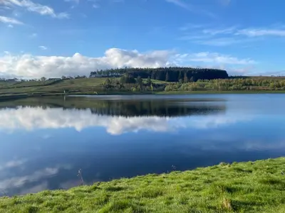 a lake with a reflection of the sky in the water at Ribble Cottage in The Ribble Valley in Whalley