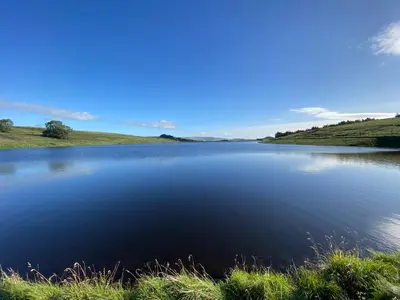a large lake in the middle of a field at Ribble Cottage in The Ribble Valley in Whalley