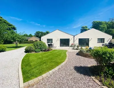 a white house with a gravel driveway at Ribble Cottage in The Ribble Valley in Whalley