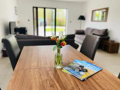 a table with a vase of flowers and a magazine at Ribble Cottage in The Ribble Valley in Whalley