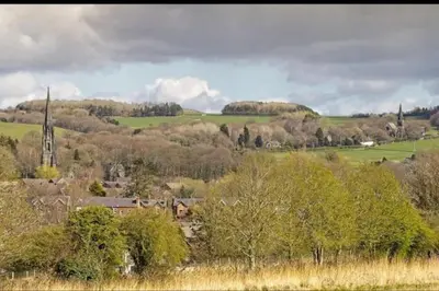 a view of a town with a church and a hill at 'Mill Cottage' Parbold in Parbold