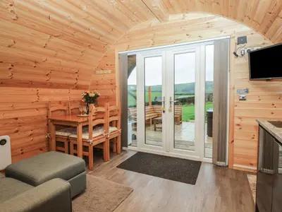 a log cabin living room with a table and a balcony at Oak in Ulverston