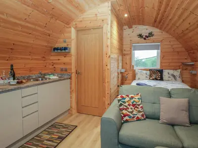 a living room with a couch and a bed in a cabin at Willow in Ulverston