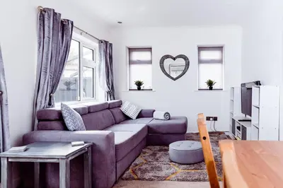 a living room with a purple couch and a window at Willow Chalet near Cartmel & Lake Windermere in Flookburgh