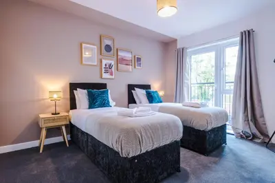 two beds in a room with a window at Formby Village Apartments By Greenstay Serviced Accommodation - Perfect For SHORT & LONG STAYS - Couples, Friends, Families & Business Travellers All Welcome - Dog Friendly - 7 in Formby