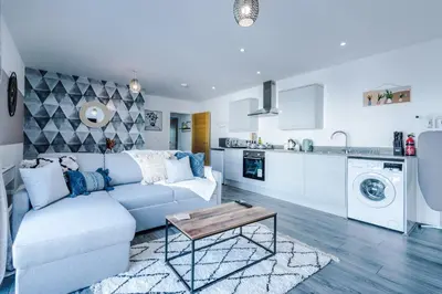 a living room with a couch and a kitchen at Formby Village Apartments By Greenstay Serviced Accommodation - Perfect For SHORT & LONG STAYS - Couples, Friends, Families & Business Travellers All Welcome - Dog Friendly - 7 in Formby