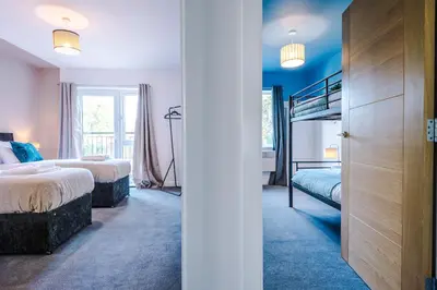 a bedroom with two beds and a bunk bed at Formby Village Apartments By Greenstay Serviced Accommodation - Perfect For SHORT & LONG STAYS - Couples, Friends, Families & Business Travellers All Welcome - Dog Friendly - 7 in Formby