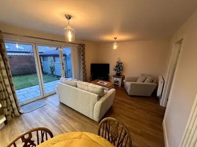 a living room with two couches and a television at The Hideaway Southport in Southport