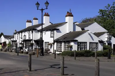 a white building with black roofs on a street at The Hideaway Southport in Southport
