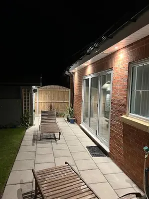 a patio with two chairs and a brick building at The Hideaway Southport in Southport