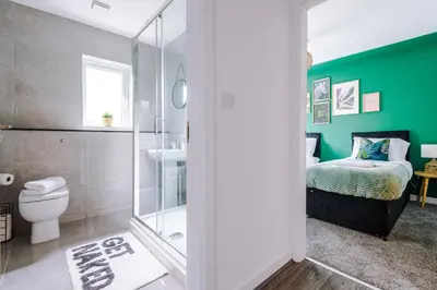 a bathroom with a toilet and a green wall at Formby Village Apartments By Greenstay Serviced Accommodation - A Luxury 2 Bed Apt - Perfect for Couples, Friends, Families & Business Travellers - FREE Parking - Dog Friendly - Fast Wi-Fi - 6 in Formby