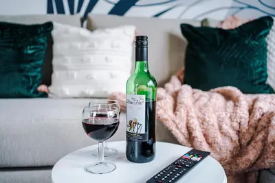 a bottle of wine and a glass on a table at Formby Village Apartments By Greenstay Serviced Accommodation - A Luxury 2 Bed Apt - Perfect for Couples, Friends, Families & Business Travellers - FREE Parking - Dog Friendly - Fast Wi-Fi - 6 in Formby