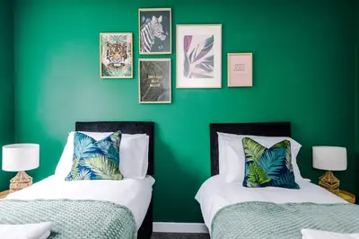 two beds in a room with a green wall at Formby Village Apartments By Greenstay Serviced Accommodation - A Luxury 2 Bed Apt - Perfect for Couples, Friends, Families & Business Travellers - FREE Parking - Dog Friendly - Fast Wi-Fi - 6 in Formby